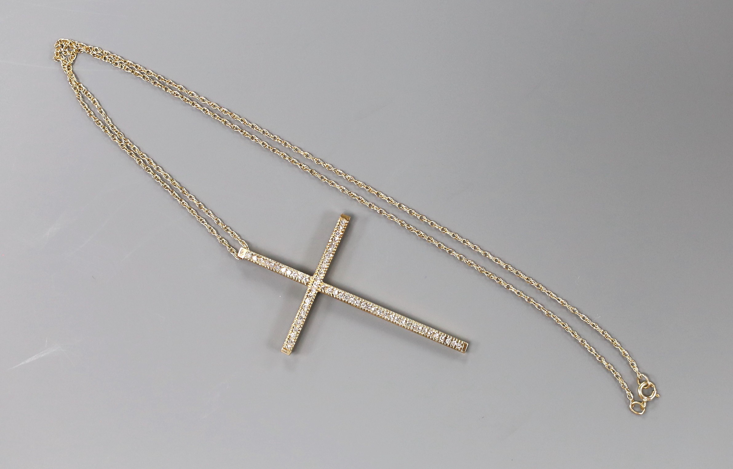 A modern 9ct gold and diamond cluster set cross pendant, 49mm, on a 9k fine link chain, 40cm, gross weight 4 grams.